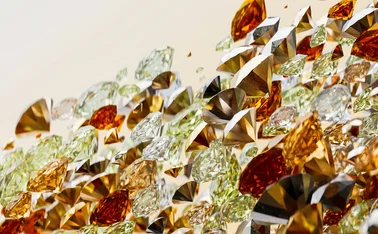 Abstract 3D composition of faceted gemstones in gold, amber, green, black and clear tones, floating in layered clusters against a warm cream background