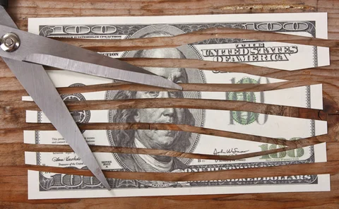 scissors cutting a dollar bill into strips