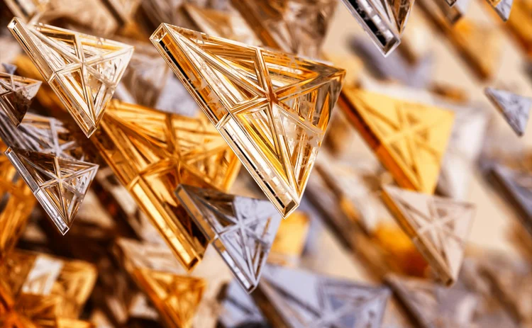 Abstract 3D rendering of metallic triangular prisms in gold, silver, and bronze tones, suspended in a dynamic, geometric pattern. Modern digital art concept with a futuristic and architectural design