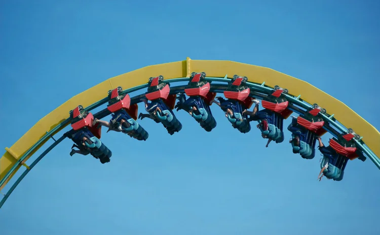 People hang upside down at the top section of a rollercoaster