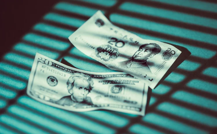 USDCNY-GettyImages-2211232756 Shadow of Venetian blinds falls on US and Chinese banknotes