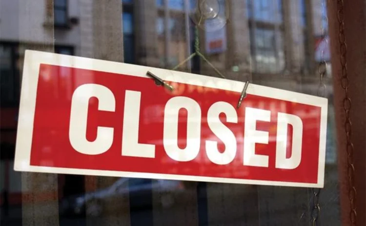 Closed sign in a shop showroom with reflections