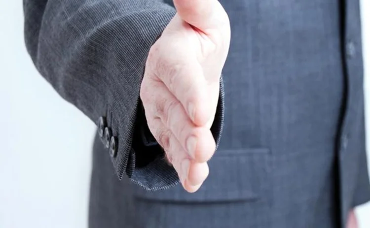 A business man makes a hand shake gesture