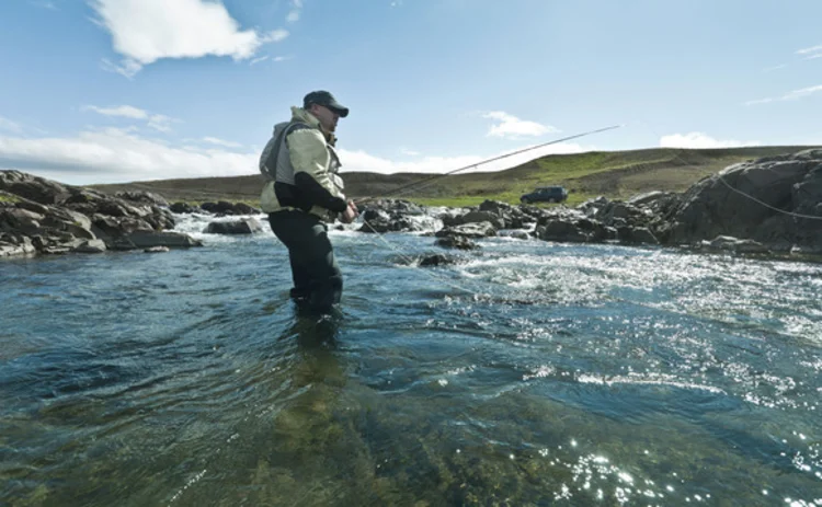 A man fly fishing in a river A man fly fishing in a river
