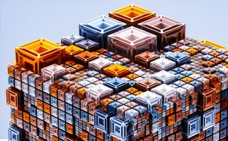 3D-rendered abstract structure composed of layered, transparent cubes in varying sizes and colours – primarily orange, blue and white – stacked in a geometric, isometric pattern against a light blue background
