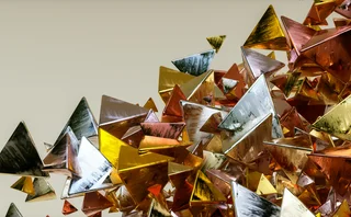 Abstract flow of brushed metallic pyramid shapes, ranging from gold to copper to silver, on a beige background