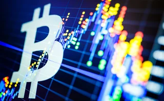 A bitcoin symbol is superimposed over a trading screen showing financial data