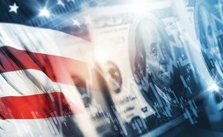 An American flag with a $100 note and an abstract financial graph
