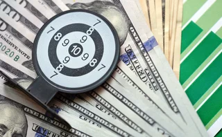 Dollar notes on a financil chart overlaid with a miniature target