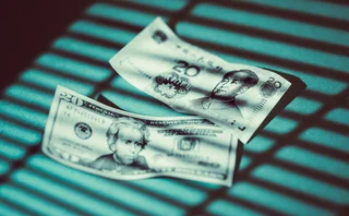 Shadow of Venetian blinds falls on US and Chinese banknotes 