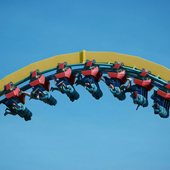People hang upside down at the top section of a rollercoaster