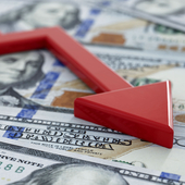 A pile of US dollars beneath a red downward pointing arrow 